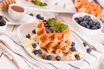 Waffles with blueberries and whipped cream.