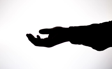 High contrast photography, against the light, hands making movements, actions, holding cell phone, pointing, hands of a young man.