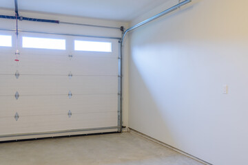 An empty garage with door and windows.