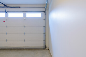 An empty garage with door and windows.