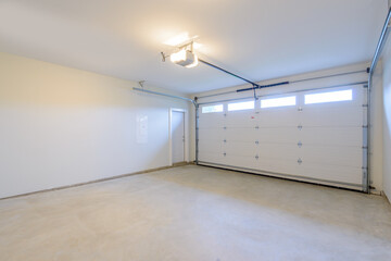 An empty garage with door and windows. - obrazy, fototapety, plakaty