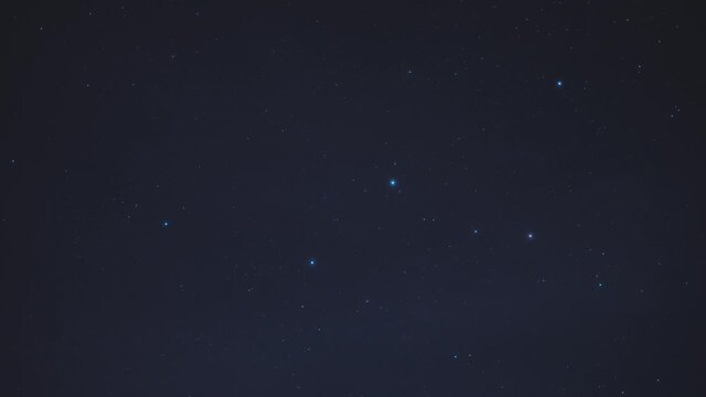 Timelapse of the movement of the constellation Cassiopeia in the night sky among the stars and cirrus clouds