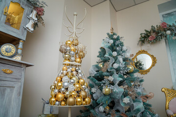 Beautiful firtree decorated with white garlands, mannequin or dummy with golden baubles. Christmas interior