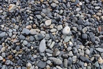 Peeble rocks on lake shore background.