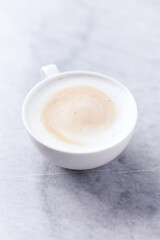 Coffee with milk on bright stone background. Close up.