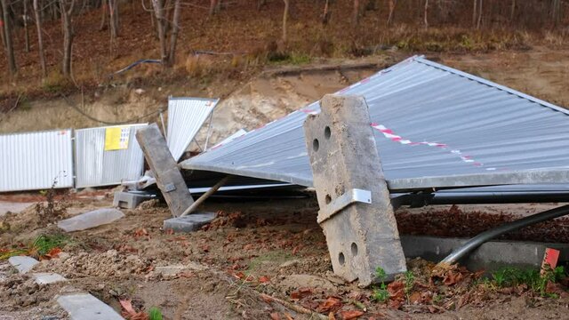 Messy Demolished Construction Site with Overturned Metal Sheet Fence Devasted and Damaged by Strong Gale Wind Tornado Hurricane