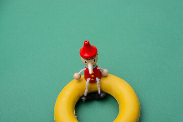 Old Pinocchio wooden doll of fairy tale character on life preserver