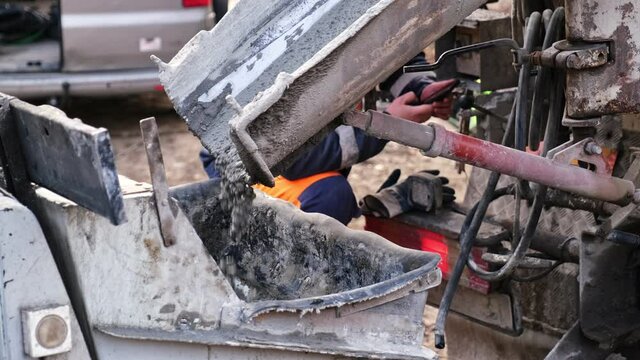 Fresh Cement Flowing Out of Mobile Concrete Mixer Truck While Contractor Operator is Distracted Using Smartphone 