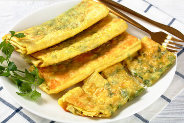 burritos with cheese and greens filings on a plate