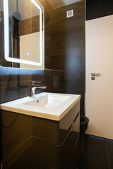 modern bathroom with dark furniture and spotlights