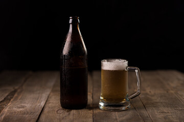 Bottle of craft beer and beer mug on a wooden table
