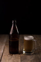Bottle of craft beer and beer mug on a wooden table