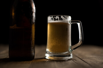 Bottle of craft beer and beer mug on a wooden table