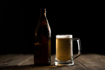 Bottle of craft beer and beer mug on a wooden table