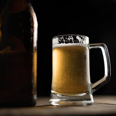 Bottle of craft beer and beer mug on a wooden table