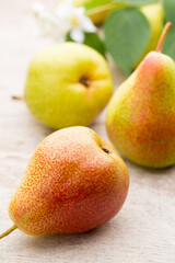 Fresh pears with leaves in a on wooden background.