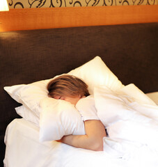 Obraz na płótnie Canvas young sleeping man lying on the bed