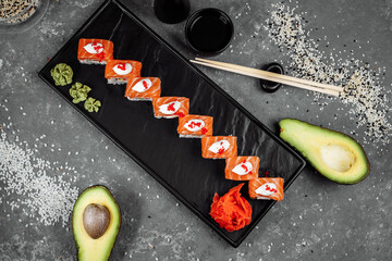 Philadelphia roll sushi with salmon, smoked eel, cucumber, avocado, cream cheese, red caviar. Sushi menu. Japanese food