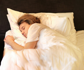 young sleeping man lying on the bed