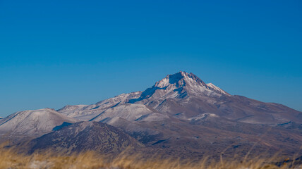 Clouds on a volcanic Erciyes mount in Kayseri. Snowy scarlet mountain. Erciyes is a large stratovolcano, reaching a height of 3,864 m it the highest mountain and most voluminous volcano of Central Ana