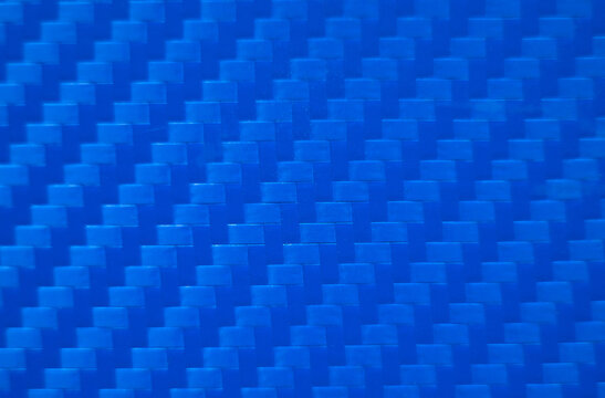 Photo of the blue carbon fiber texture. Blue vinyl film for pasting sports cars. Racing style. Sporty blue background.