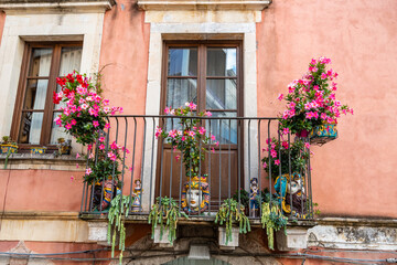 Fototapeta na wymiar Typical Sicilian balcony in Taormina full of flowers and decorations