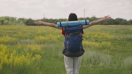 girl hipster thousand-year-old with a backpack on her back goes to travel, active tourist rest in hiking conditions, life of adventure, dream of female happiness and freedom, yoga and fitness mat