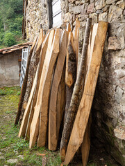 Varios listones de maderas cortadas apiladas contra un muro de piedra en el pueblo de Carmona, en...