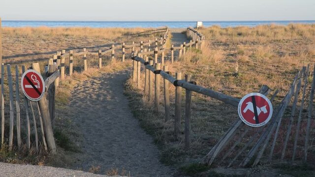Chemin menant &agrave; la plage du Barcar&egrave;s, Pyr&eacute;n&eacute;es-Orientales, Roussillon, Occitanie. Des barri&egrave;res et des panneaux emp&ecirc;chent le public d'aller pi&eacute;tiner la v&eacute;g&eacute;tation.