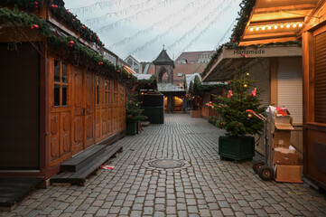 Empty dark alley with closed sale stalls before the opening of the Christmas market, hoping the...