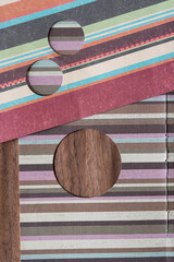 striped scrapbooking paper with circular cutouts on wood
