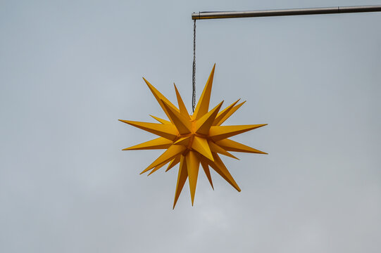 Yellow Christmas Star Hanging On A Pole Against A Grey Winter Sky, Copy Space, Selected Focus