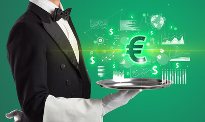 Handsome young waiter in tuxedo holding currency icons on tray