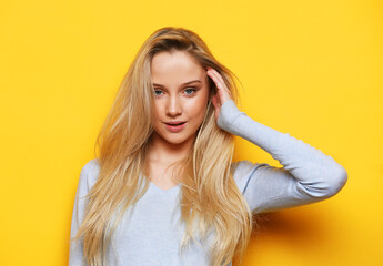 Studio shot of good-looking beautiful woman isolated against yellow background.