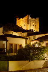 Keep of Bragan&ccedil;a Castle in Portugal, illuminated at night, with houses from the citadel in the foreground.