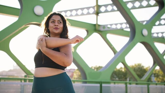Close up of young overweight woman exercising outdoors in bridge.