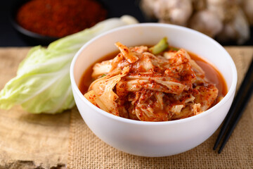 Korean kimchi cabbage in a bowl on wooden, Asian fermented food