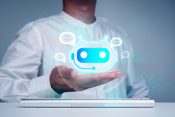 Digital chatbot concept. Virtual bot icon with speech balloons symbol on hand while using computer for providing access to information and data online, AI robot application, innovation and technology.