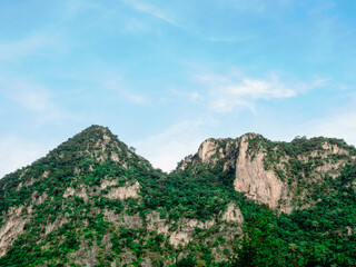 Nature background. Green tree, jungle on the beautiful shape mountain on blue sky and cloud with sunshine on sunny day.