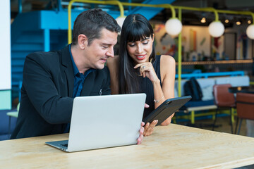 Caucasian couple in luxury formal wear is planning for wedding and honeymoon by looking at possible travel destination for booking