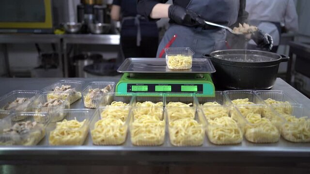 Chef prepares takeaway food in plastic containers, pasta and mushrooms charity lunch, small business, food delivery