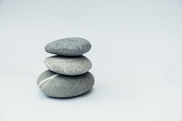 Fototapeta na wymiar Stone cairn on light background, stones tower, simple poise stones. Purity harmony and Balance Concept.