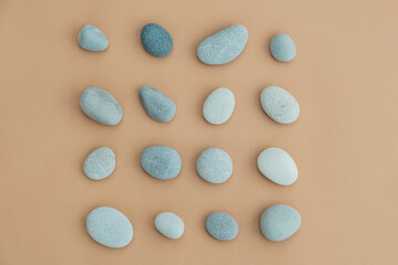 Set of sea stones of a round form on beige background. Top view of a collection of smooth pebbles.