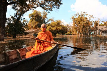 Fototapeta na wymiar Lifstyle of boat transportation of monk in Ayutthaya during flood issue in Thailand