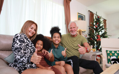 Play ful family site relax on sofa in living room on holiday time, Portrait happy family with thumbs upaction