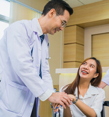 Fototapeta premium doctor man shake hand women patient sitting on wheelchair