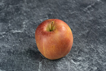 Ein frischer Apfel auf einer grauen marmorierten Küchenplatte