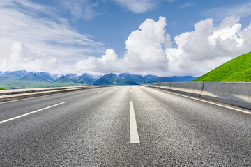 Asphalt highway and mountain under blue sky.Empty road and mountain nature background.