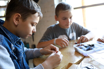 Friends making bracelets at workshop