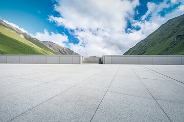 Empty square floor and mountains under blue sky